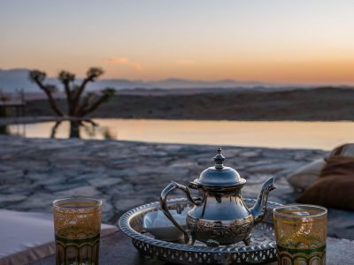 A selective focus closeup shot of a typical Moroccan mint tea set on the table in Agafay desert, Marrakech